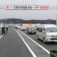 三陸沿岸道路の全線開通を祝い、通り初めを行う関係車両＝18日午後、岩手県久慈市