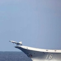 中国海軍の空母「遼寧」から発艦する戦闘機とヘリコプター（防衛省統合幕僚監部提供）