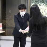 法務省の鷦鷯昌二参事官（奥）に署名を手渡す小関代里子さん＝22日午後、東京都千代田区