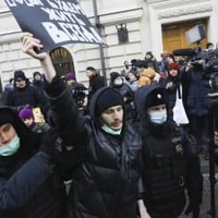 28日、モスクワのロシア最高裁前で、デモ参加者を拘束する警察官（AP＝共同）