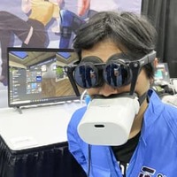 仮想現実（VR）対応端末を装着して来場者に説明するパナソニックの子会社シフトールの岩佐琢磨CEO＝3日、米ラスベガス（共同）