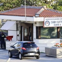 9日、沖縄県北谷町の米軍キャンプ・フォスターのゲート前で車両のチェックをする関係者