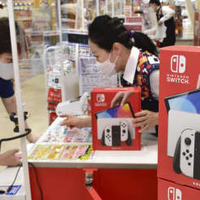 大阪市内の家電量販店で「ニンテンドースイッチ」を購入する男性（左）＝2021年10月
