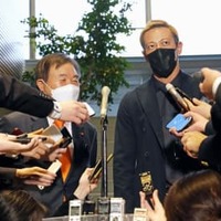 首相官邸で取材に応じる本田圭佑選手。左は自民党の遠藤選対委員長＝4日午後