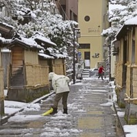 金沢市の中心部、長町武家屋敷跡周辺で除雪をする人＝5日午前