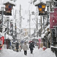 雪が降り続く中、滋賀県長浜市内を歩く人たち＝5日午後