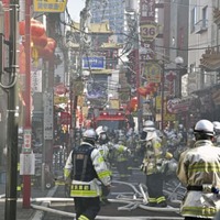 横浜中華街の火災現場付近で、消火活動をする消防隊員ら＝11日午前11時24分、横浜市