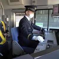 JR山手線の自動運転試験で、運転席のボタンを押す運転士＝25日、東京都内