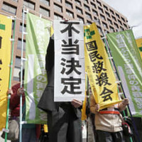 再審開始を認めない決定に、名古屋高裁前で「不当決定」と書かれた紙を掲げる弁護士＝3日午前