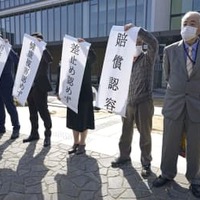 小松基地騒音訴訟の控訴審判決後、名古屋高裁金沢支部前で旗を掲げる原告側関係者＝16日午後