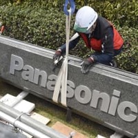 パナソニック本社正門前にある社名が刻まれた石のデザインの変更作業＝20日、大阪府門真市