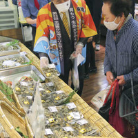法被を着て鶴屋百貨店の食料品売り場に立ち、熊本県産アサリの購入を勧める蒲島郁夫知事＝17日午前、熊本市