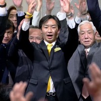参院石川選挙区補選で当選を確実とし、万歳する宮本周司氏（中央）＝24日夜、金沢市