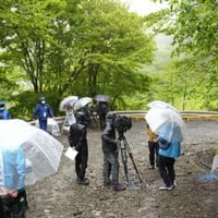 規制線が張られた現場周辺に集まる報道陣＝29日午後、山梨県道志村