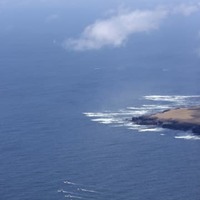 4月30日、北海道・知床半島沖で捜索する漁船団（左下）。奥は国後島（共同通信社ヘリから）