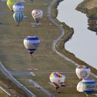 佐賀インターナショナルバルーンフェスタで次々と舞い上がる色鮮やかな熱気球＝2021年11月、佐賀市