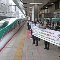 東北新幹線が完全復旧して通常ダイヤとなり、車両に向かって横断幕を掲げるJR東日本の社員ら＝13日午前、JR東京駅