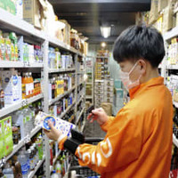 商品を保管する拠点で飲料を手にするオニゴの従業員＝20日、東京都目黒区