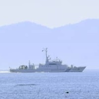 11日、北海道・知床半島の羅臼港沖合を航行する海上保安庁の巡視船。後方は北方領土・国後島