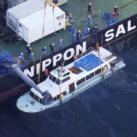 海面上までつり上げられた観光船「KAZU　1」＝26日午後6時54分、北海道斜里町沖（共同通信社ヘリから）