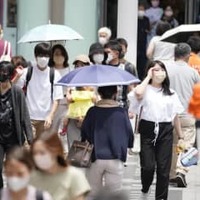 猛烈な暑さの中、JR浦和駅前を行き交う人たち＝26日午前、さいたま市