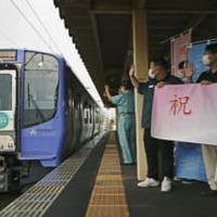 阿武隈急行が全線再開され、福島学院前駅で車両を出迎える学生ら＝27日午前、福島市