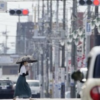 梅雨明けしたとみられる栃木県佐野市で、猛暑の中を歩く女性＝27日午後
