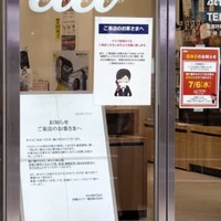 KDDI（au）の大規模通信障害について謝罪の看板を掲げるJR渋谷駅近くのauショップ＝3日午後、東京都渋谷区