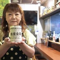 募金箱を持つ「知床小さな居酒屋　まりの店」店主の工藤真理子さん＝6月24日、札幌市