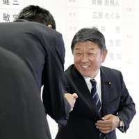 当選を確実にした候補者とタッチする自民党の茂木幹事長＝10日午後9時33分、東京・永田町の党本部