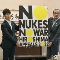 広島市役所で、松井一実市長（右）に「ヒロシマ・アピールズ」のポスターを贈呈する佐藤可士和さん＝15日午前