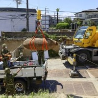 信管が取り除かれた不発弾をトラックに積み込む陸上自衛隊員ら＝24日午後、大阪府吹田市