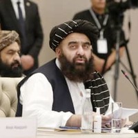 26日、ウズベキスタンの首都タシケントで行われた国際会議で演説するアフガニスタンのムッタキ外相（共同）