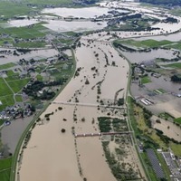 大雨の影響で増水した、山形県の南陽市（右側）と川西町を流れる最上川＝4日午後2時10分（共同通信社機から）