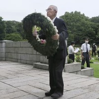 横浜市の英連邦戦死者墓地で献花に向かう日本基督教団の関田寛雄牧師＝6日午前