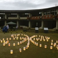 児童や教職員84人が亡くなった宮城県石巻市立大川小の中庭で、四つ葉のクローバーの形に設置された108個の紙灯籠＝14日夕、宮城県石巻市