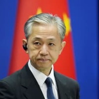 記者会見する中国外務省の汪文斌副報道局長＝18日、北京（共同）