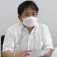 記者会見で和解内容について話す原告側代理人の藤井裕弁護士＝23日午前、広島市