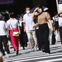 強い日差しの中、大阪・梅田を歩く人たち＝6月28日