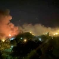 15日、イランの首都テヘランにあるエビン刑務所から上がる煙（ロイター＝共同）