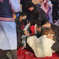 ソウル・梨泰院で起きた事故の現場付近で、介抱される人＝30日未明（共同）