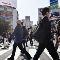 東京・渋谷のスクランブル交差点を行き交う人たち