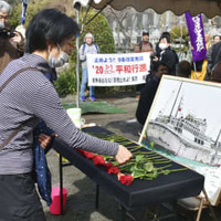 「第五福竜丸」の被ばくから66年となり、無線長久保山愛吉さんを悼む墓前祭でバラを手向ける参列者＝1日、静岡県焼津市