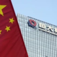 中国恒大集団の本社が入るビル。左はビル前の通りに掲げられた中国国旗＝9月、中国広東省深☆（土ヘンに川）市（共同）