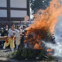 成田山新勝寺の「納め札お焚き上げ」で、お札を「智慧の火炎」に投げ入れる山伏姿の僧侶＝28日午前、千葉県成田市