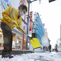 まとまった積雪から一夜明け、道路の除雪作業をする人たち＝7日午前、東京・新橋