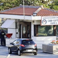 9日、沖縄県北谷町の米軍キャンプ・フォスターのゲート前で車両のチェックをする関係者