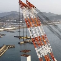 大型クレーン船でつり上げられる巨大ケーソン＝2日午前、高知港（四国地方整備局高知港湾・空港整備事務所提供）