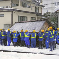 線路に滑り落ちた小屋を撤去する作業員ら＝3日午後4時40分ごろ、山形市