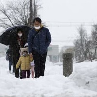 大雪が降り続く中、滋賀県米原市を歩く人たち＝6日午後